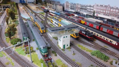 Een bonte verzameling treinen in actie op de modelspoorbaan